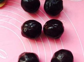 静止过程中，用豆沙把蛋黄包裹好，豆沙的量取决于蛋黄的大小，它们在一起大概35克左右就可以