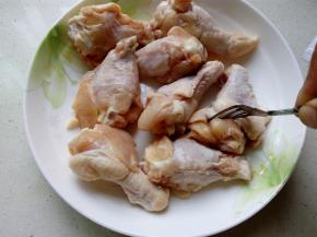 用叉子在鸡翅上扎一些小孔，以帮助腌制时更加的入味。