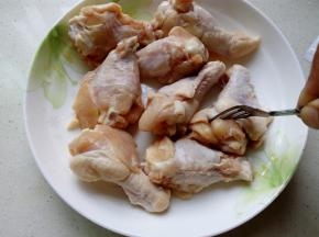 用叉子在鸡翅上扎一些小孔，以帮助腌制时更加的入味。
