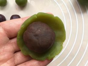 取一桃山皮，压成中间稍厚边缘薄的薄片，放上馅料，
利用拇指和食指之间的虎口将桃山皮往上推至收囗