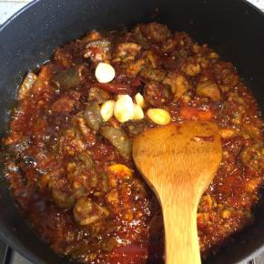 然后倒入大蒜瓣，继续不停翻炒