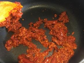 锅内倒入生糍粑辣椒，不停翻炒，翻炒到辣椒颜色加深