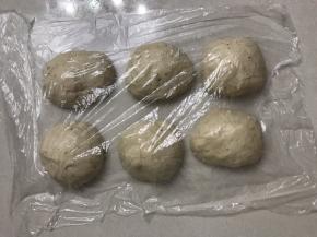 轻拍打面团排气，分割成6 份每份150 克滚圆，盖上保鲜膜松弛15 分钟（余下的面团烤一个小面包）