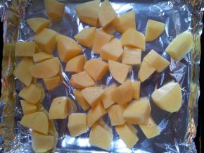 烤盘铺上锡纸。倒上切好的土豆。然后加入融化的黄油拌均匀。