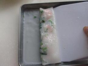 用刮板从一边刮起，折叠着往前翻卷。