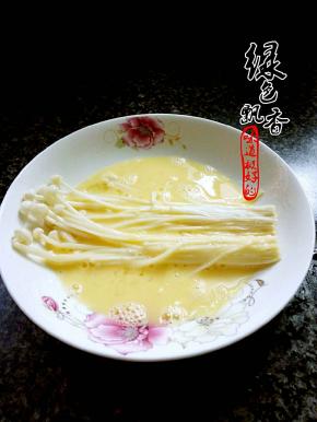 将金针菇放入蛋液，均匀沾上蛋液