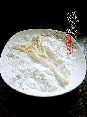 将沾好蛋液的金针菇，放入干淀粉中，裹匀，抖掉多余的淀粉