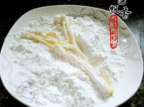 将沾好蛋液的金针菇，放入干淀粉中，裹匀，抖掉多余的淀粉