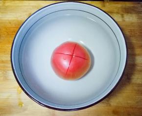 西红柿洗干净，划十字刀，放入碗中，倒入开水烫一会皮，容易去皮