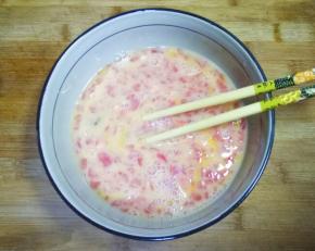 鸡蛋打入碗中搅打均匀，加入西红柿丁