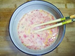 鸡蛋打入碗中搅打均匀，加入西红柿丁