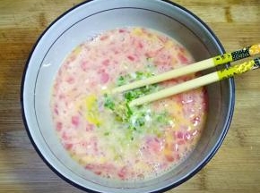 将榨菜末和小葱放入鸡蛋中搅打均匀。