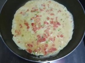 锅中倒适量油烧热，倒入鸡蛋液摊均匀。