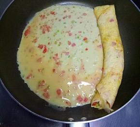 然后再次倒入适量鸡蛋液，等鸡蛋液表面半凝固时，从左往右卷起来，依次用完所有鸡蛋液。