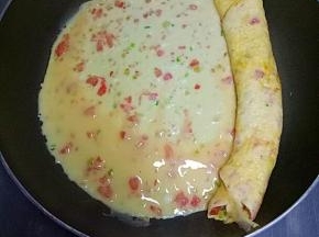 然后再次倒入适量鸡蛋液，等鸡蛋液表面半凝固时，从左往右卷起来，依次用完所有鸡蛋液。