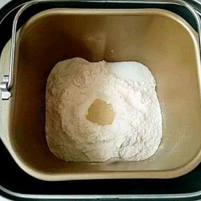 首先称好所有材料，先把液体材料放去面包机中，接着放入高粉，盐和糖对角线放，中间戳个小坑放酵母，启动和面功能20分钟