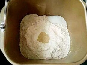 首先称好所有材料，先把液体材料放去面包机中，接着放入高粉，盐和糖对角线放，中间戳个小坑放酵母，启动和面功能20分钟