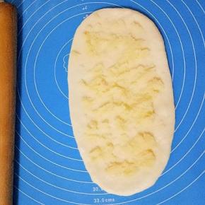 松弛好的面团擀成椭圆形，放上适量椰蓉