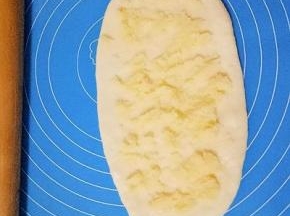 松弛好的面团擀成椭圆形，放上适量椰蓉