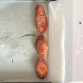 蒸熟的肠粉，用刮板从一头轻轻铲起来，放入香肠片。