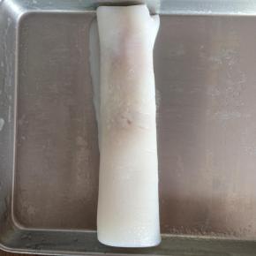 借助刮板，将肠粉卷起来。