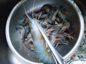 用食品简单将虾的爪子剪掉。