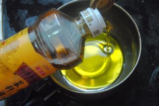 金龙鱼菜籽油倒入奶锅内