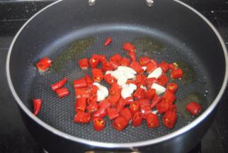 热锅，倒入适量的金龙鱼外婆乡小榨菜籽油，爆香蒜末后放入湿辣椒炒至表皮起泡