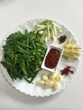 韭菜清洗干净后切成段，葱白切成段，生姜切成丝，干辣椒切成段，蒜瓣剥皮拍碎即可！花椒5克，豆瓣酱一勺备用！