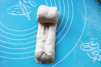 取一个面团，再次排气，我进行了两次擀卷的过程，最后如图两边折上去卷起来。