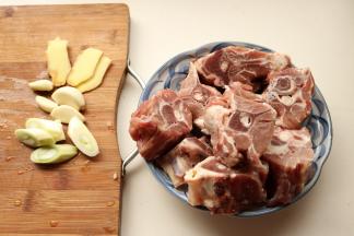 羊蝎子室温解冻，浸泡2小时以上去除血水，葱姜蒜切片。