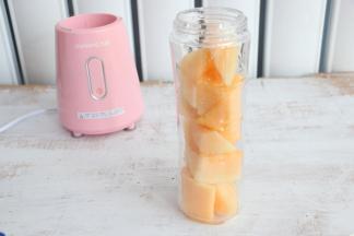 将哈密瓜放入果汁机的杯子中。