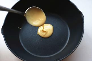 用一个勺子舀一勺面糊，从一个点上倒入锅内，让面糊自然摊开，成一个圆饼。