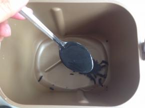 面包桶内加入水、黑芝麻酱、糖和盐。