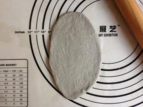 将松驰好的面团擀成椭圆形。