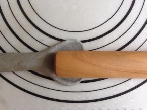 搓成约25CM的长条状，其中一端用擀成棍压扁。