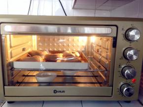 烤箱内放置一碗热开水，温度调到30度，将面包坯放入东菱烤箱内发酵30分钟。