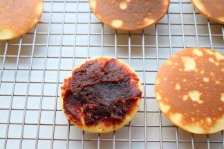 取一片饼皮，加上红豆沙，再盖上另一片，铜锣烧就做好了。