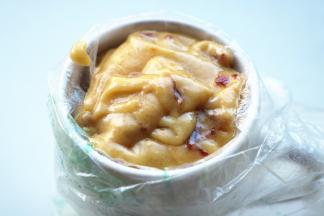 把裱花袋套在杯子上，将面糊装进去。