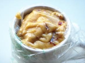 把裱花袋套在杯子上，将面糊装进去。