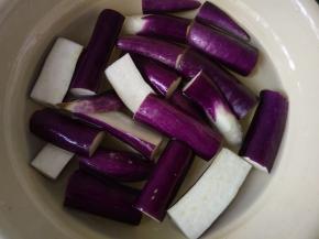 茄子切条状，浸泡在含有白醋和盐的水中，加白醋防止氧化，加盐可以让茄子不吸油