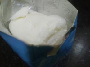 剪开纸盒，可以看到一大块牛奶冰已成碎冰沙～