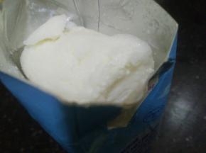 剪开纸盒，可以看到一大块牛奶冰已成碎冰沙～