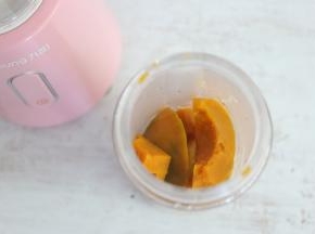 将蒸熟的南瓜放入果汁机杯子中。