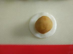 取一个白色面团包入馅料。