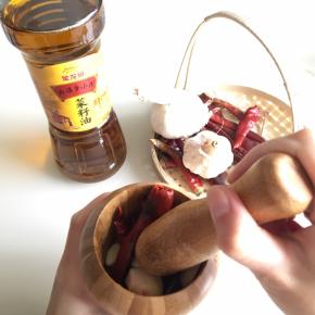 把辣椒、大蒜、仔姜放入蒜臼中，舂碎