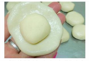 将松弛好的水油皮和油酥都分成10等份，揉成小团子。之后将油皮按扁，中间放一个油酥，像包包子一样包起来，接口向下摆放好。