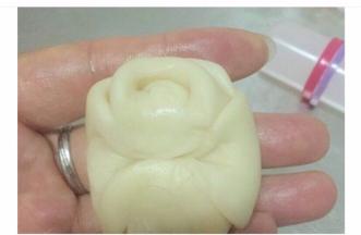 将上步的团子，两端向中间折叠，之后按扁，变成片状，放入豆沙包好的咸蛋黄。