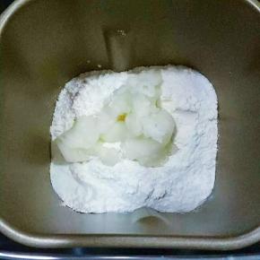 面包机里先放液体:牛奶、鸡蛋液、高筋面粉、盐和糖对角线放，中间放酵母，然后放入80克汤种面糊。启动面包机和面功能20分钟