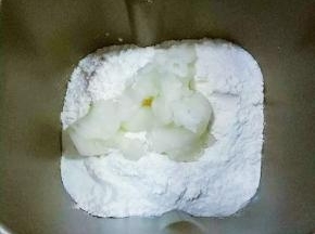 面包机里先放液体:牛奶、鸡蛋液、高筋面粉、盐和糖对角线放，中间放酵母，然后放入80克汤种面糊。启动面包机和面功能20分钟